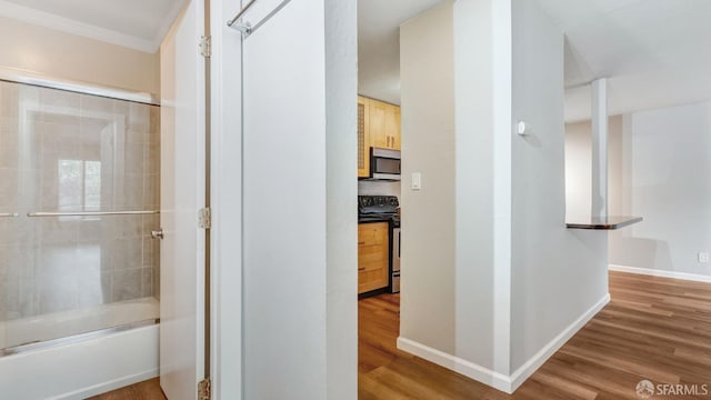 bathroom featuring bath / shower combo with glass door and hardwood / wood-style floors