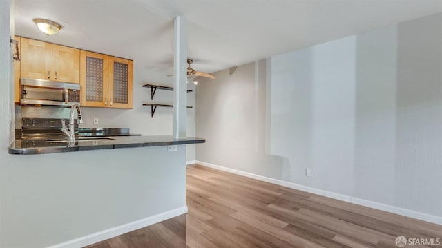 kitchen featuring light brown cabinetry, sink, light hardwood / wood-style flooring, kitchen peninsula, and ceiling fan