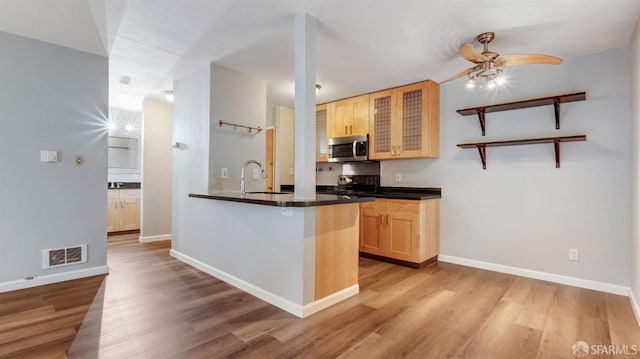 kitchen with light brown cabinetry, sink, range, light hardwood / wood-style floors, and kitchen peninsula