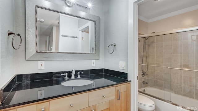 full bathroom featuring toilet, vanity, shower / bath combination with glass door, and crown molding