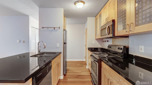 kitchen with stainless steel appliances, sink, light brown cabinets, and light hardwood / wood-style floors