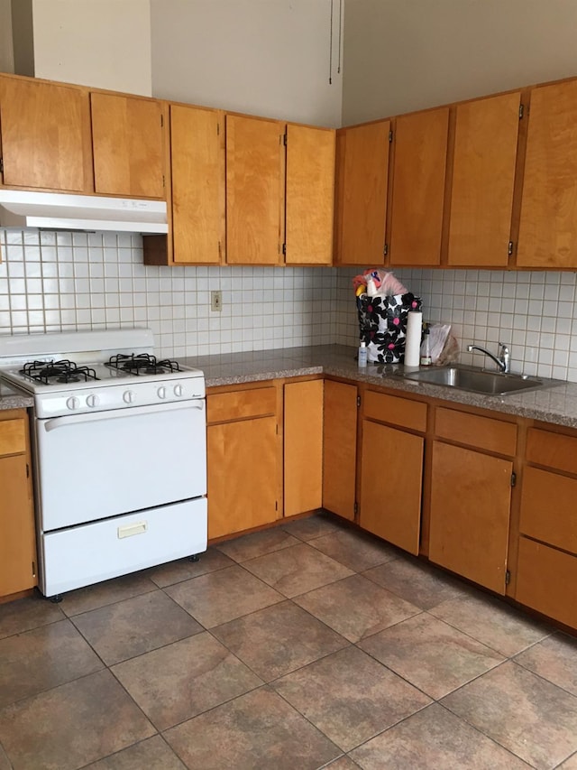 kitchen featuring sink, white gas stove, and tasteful backsplash