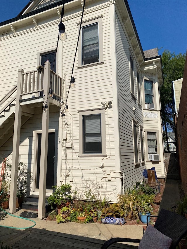 view of side of home featuring cooling unit and a balcony