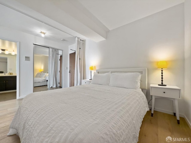 bedroom featuring ensuite bath and light hardwood / wood-style flooring