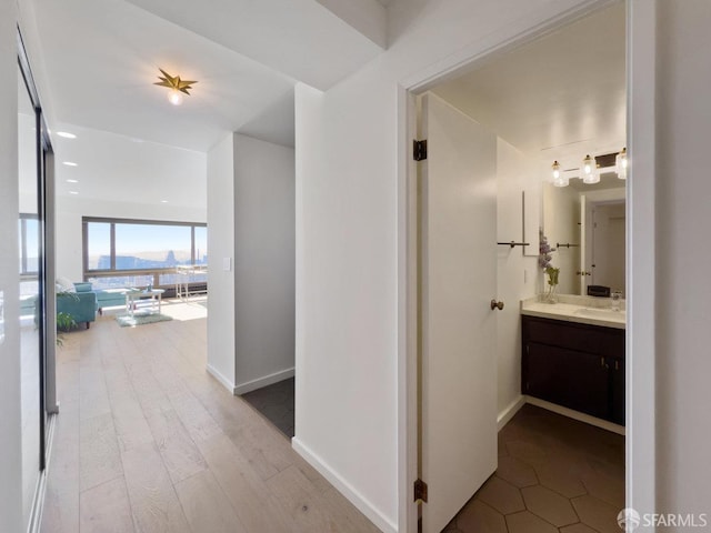 hall with expansive windows, a mountain view, and light hardwood / wood-style floors