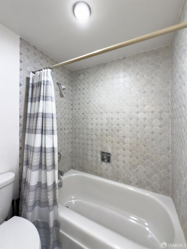 bathroom with shower / bath combination with curtain and toilet