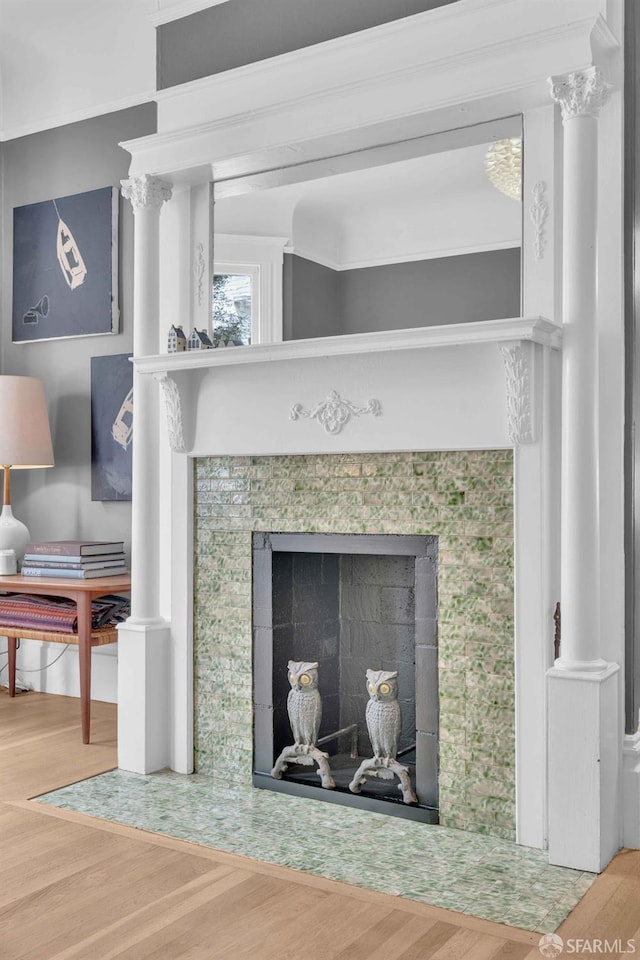 interior details with a tile fireplace and wood finished floors