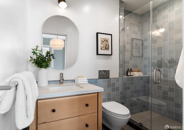 bathroom featuring vanity, toilet, and a shower with shower door