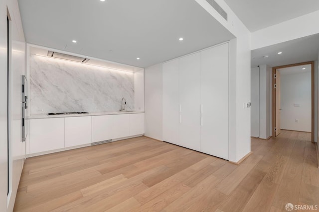 empty room with sink and light hardwood / wood-style floors