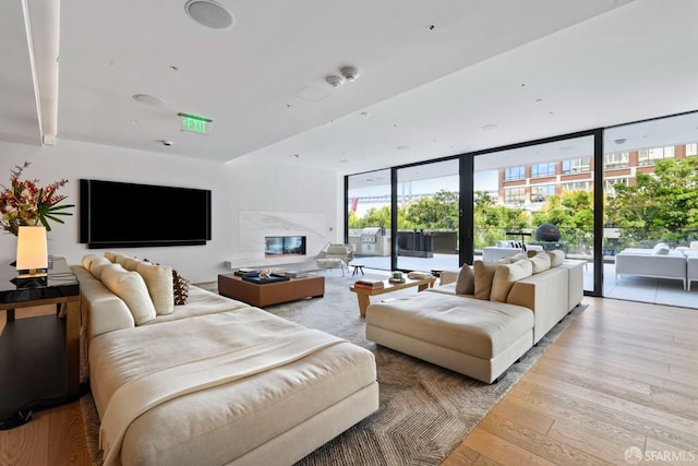 living room with floor to ceiling windows and light hardwood / wood-style flooring