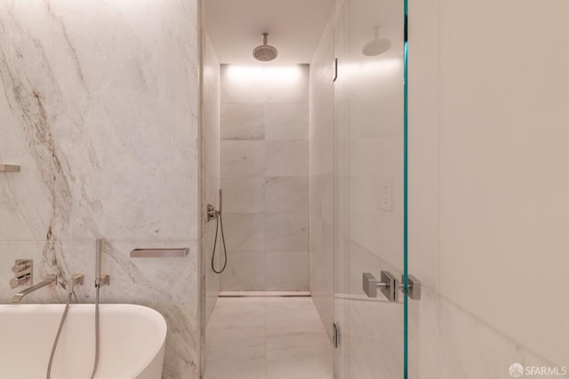 bathroom featuring tile walls and separate shower and tub