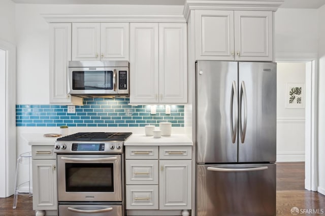 kitchen featuring tasteful backsplash, appliances with stainless steel finishes, dark wood-style flooring, light countertops, and white cabinetry