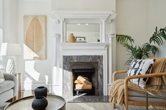 living area with ornate columns and a high end fireplace