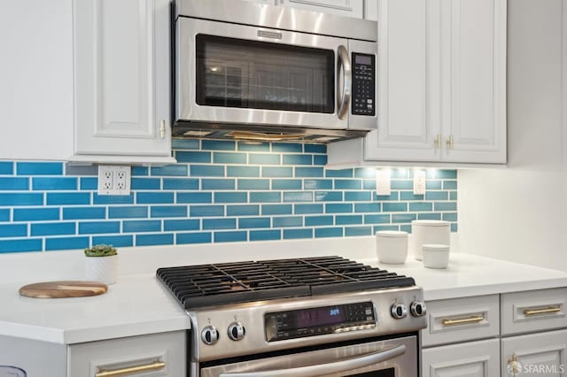 kitchen with stainless steel appliances, white cabinets, light countertops, and tasteful backsplash