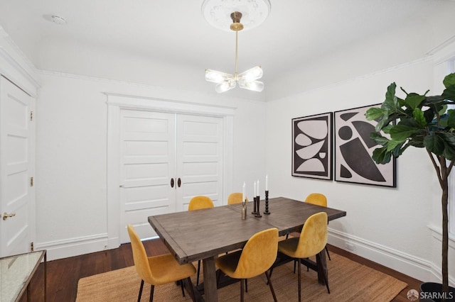 dining space with baseboards, a chandelier, and dark wood-style flooring