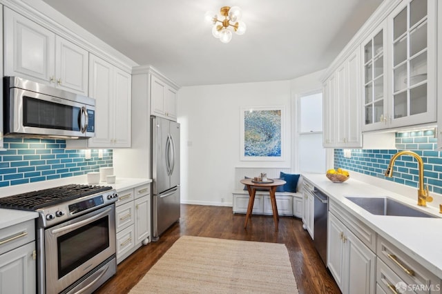 kitchen with white cabinets, glass insert cabinets, stainless steel appliances, and light countertops