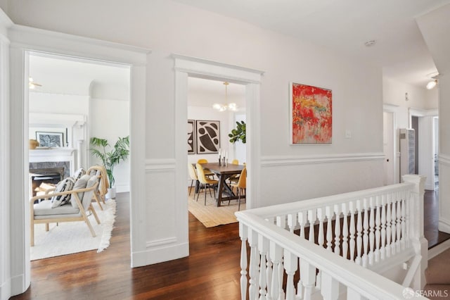 hallway with dark wood-style floors and a chandelier