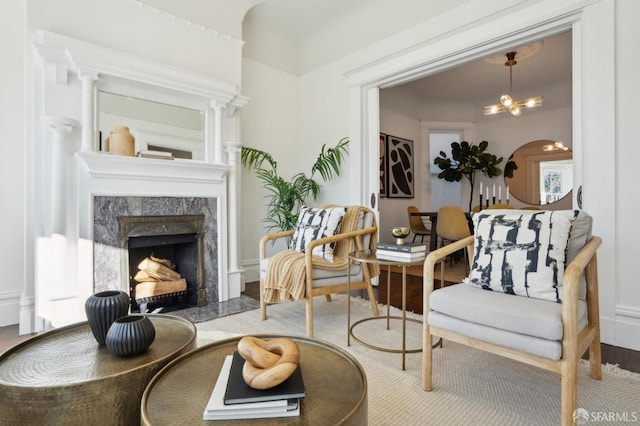 living area with light wood-style floors, a chandelier, and a fireplace