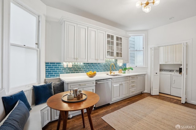 kitchen with a sink, white cabinets, light countertops, dishwasher, and glass insert cabinets