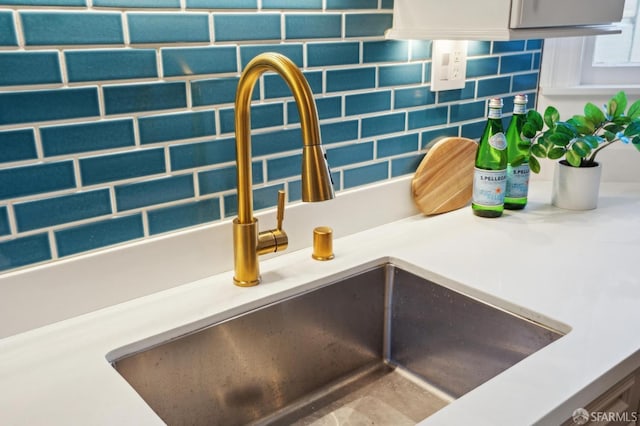 room details with decorative backsplash, light countertops, and a sink