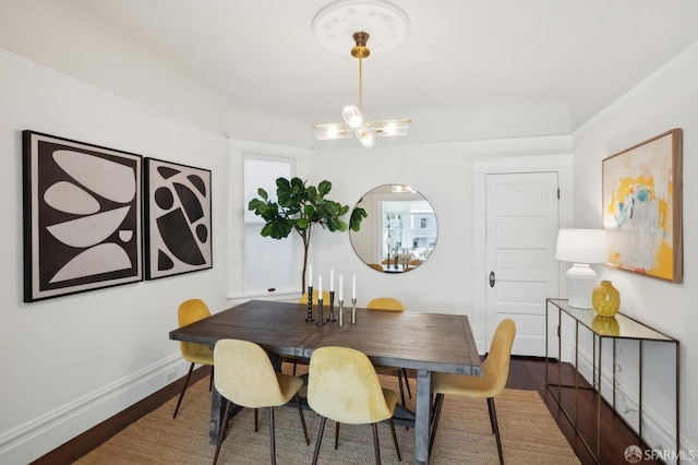 dining area featuring dark wood-type flooring, an inviting chandelier, and baseboards