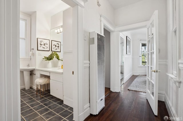 bathroom with a heating unit, wood finished floors, and baseboards