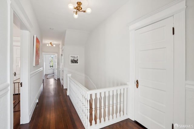 hall featuring an inviting chandelier and dark wood finished floors