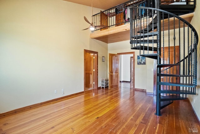 stairway with hardwood / wood-style floors and a high ceiling