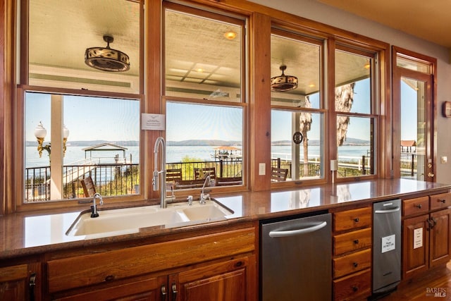 kitchen with a water view, stainless steel dishwasher, and sink