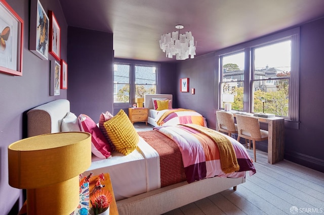 bedroom with an inviting chandelier and hardwood / wood-style floors