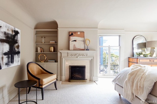 carpeted bedroom featuring a fireplace with flush hearth and lofted ceiling