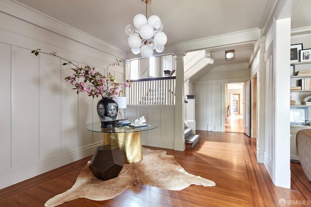 dining area featuring plenty of natural light, an inviting chandelier, ornamental molding, and a decorative wall