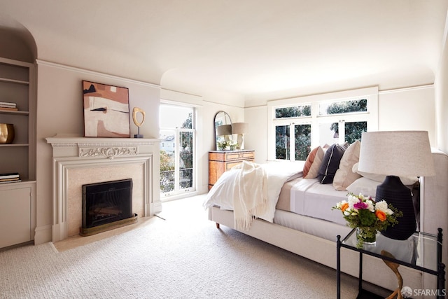 bedroom with a fireplace with flush hearth and carpet