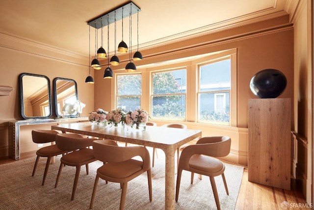 dining area featuring ornamental molding and light wood-type flooring
