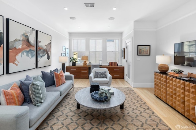 living area with recessed lighting, baseboards, visible vents, and light wood finished floors