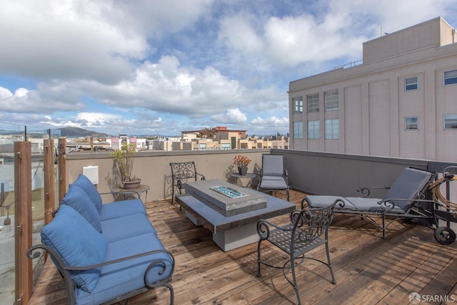 deck featuring an outdoor living space with a fire pit