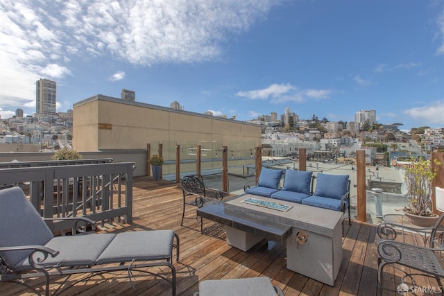 wooden terrace featuring an outdoor living space with a fire pit and a view of city