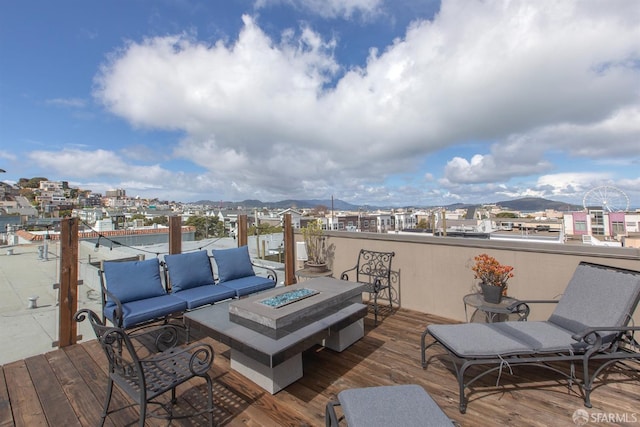 deck featuring an outdoor living space with a fire pit