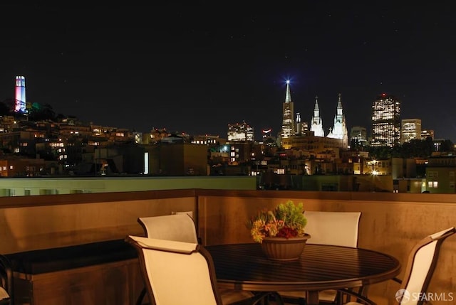 patio at twilight featuring a view of city lights