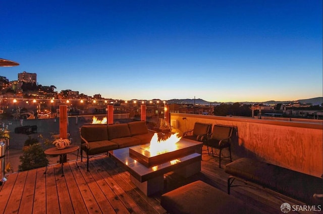 view of patio / terrace featuring a wooden deck and an outdoor living space with a fire pit