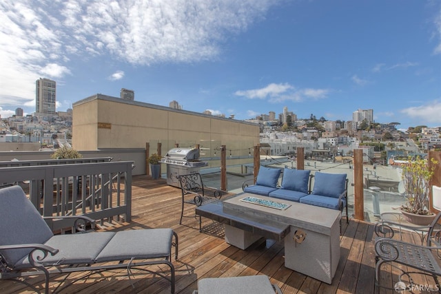 deck with a city view, a grill, and an outdoor living space with a fire pit