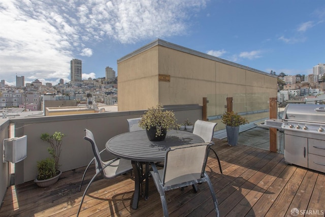 wooden deck featuring grilling area, a view of city, and outdoor dining space