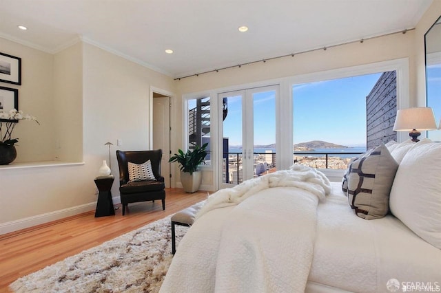 bedroom with a mountain view, hardwood / wood-style floors, access to outside, and crown molding