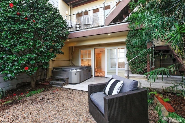 view of patio with a balcony and a hot tub