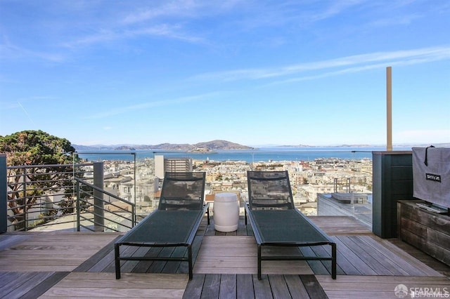 wooden terrace with a water and mountain view