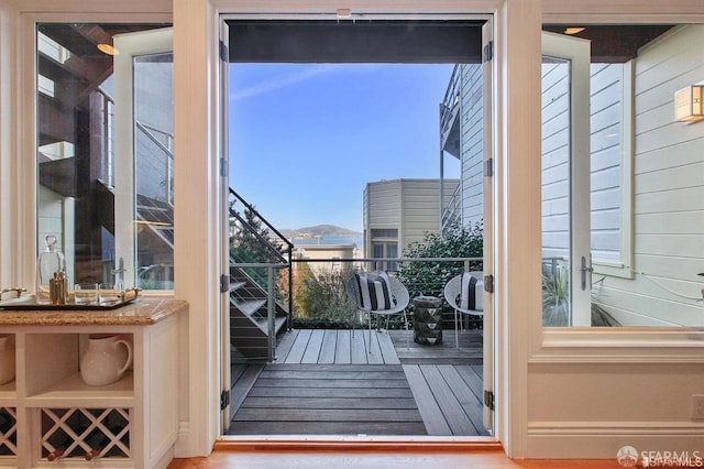 doorway with wooden walls and hardwood / wood-style floors