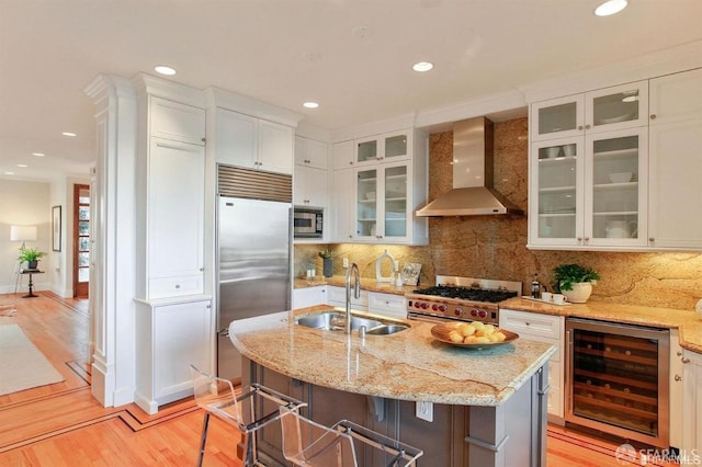 824 Green St, San Francisco, CA 94133 - kitchen with beverage cooler, wall chimney range hood, built in appliances, white cabinetry, and light wood finished floors