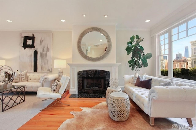 living room with crown molding, hardwood / wood-style floors, and a high end fireplace