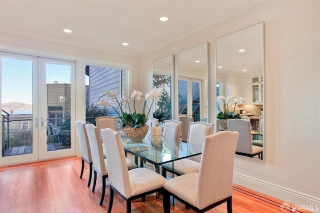 dining room featuring light hardwood / wood-style floors, crown molding, and french doors