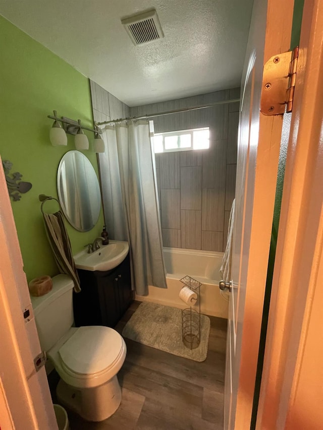 3740 26th Ave, Sacramento, CA 95820 - full bathroom with wood finished floors, shower / bathtub combination with curtain, vanity, and a textured ceiling